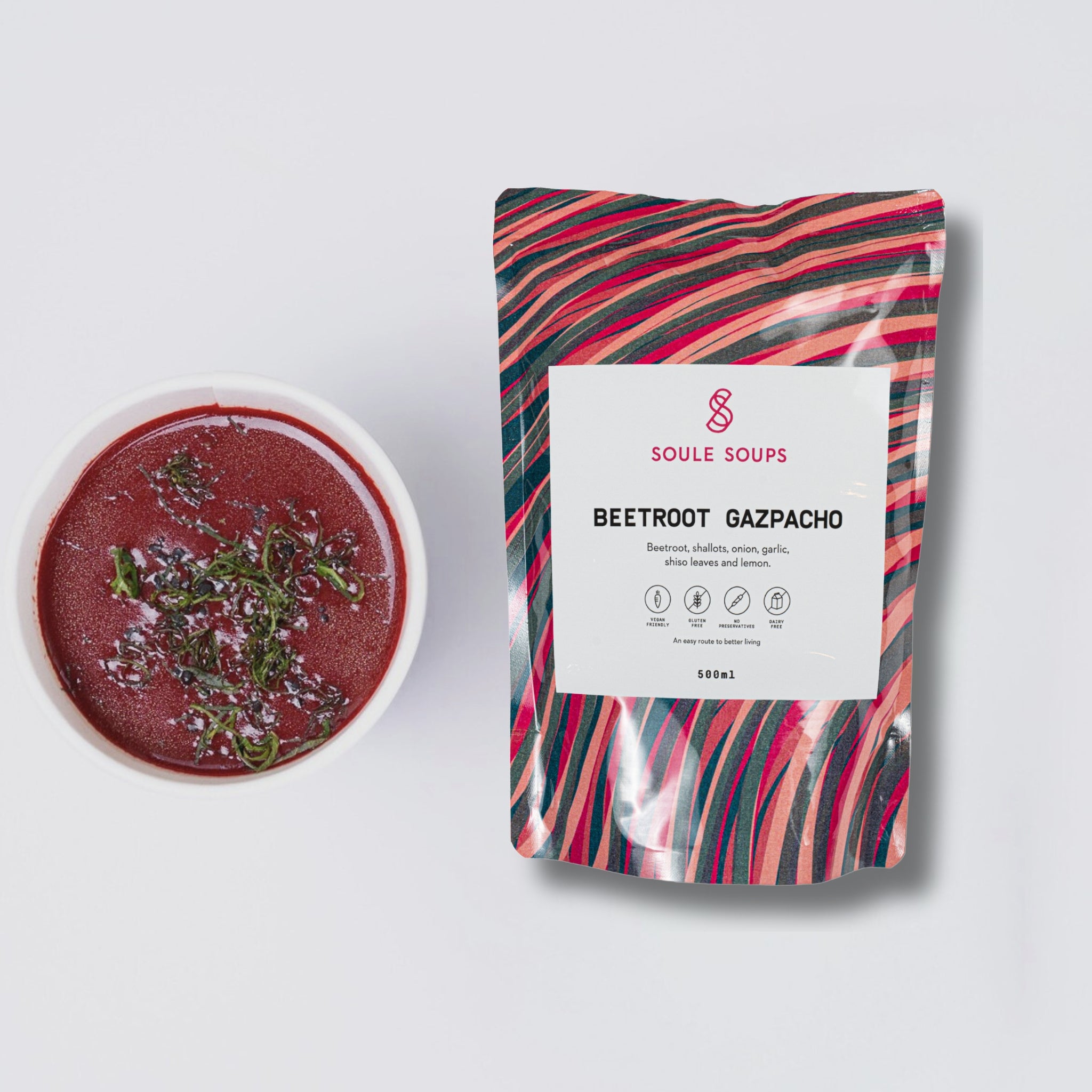 Beetroot gazpacho in a bowl with a Soule Soups package on a white background
