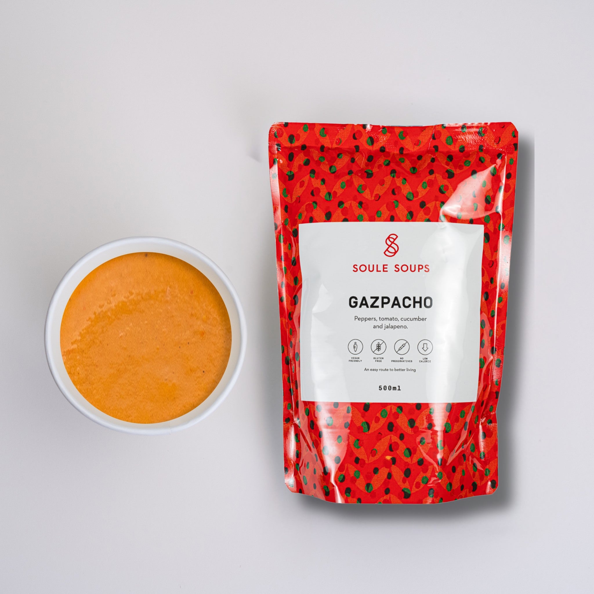 Soule Soups Gazpacho package next to a bowl of orange soup on a light gray background