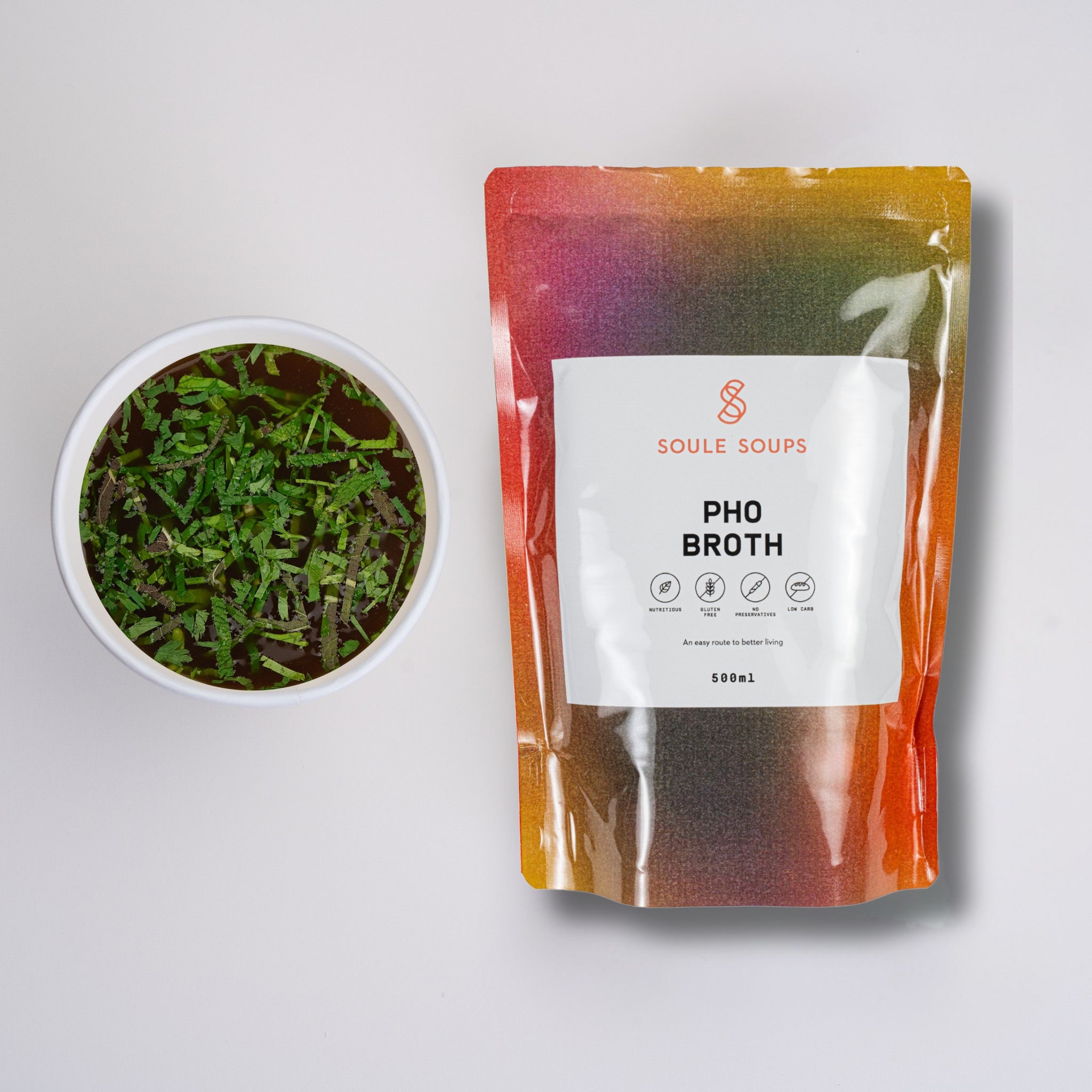 Soule Soups Pho Broth package with a bowl of broth and greens on a light gray background