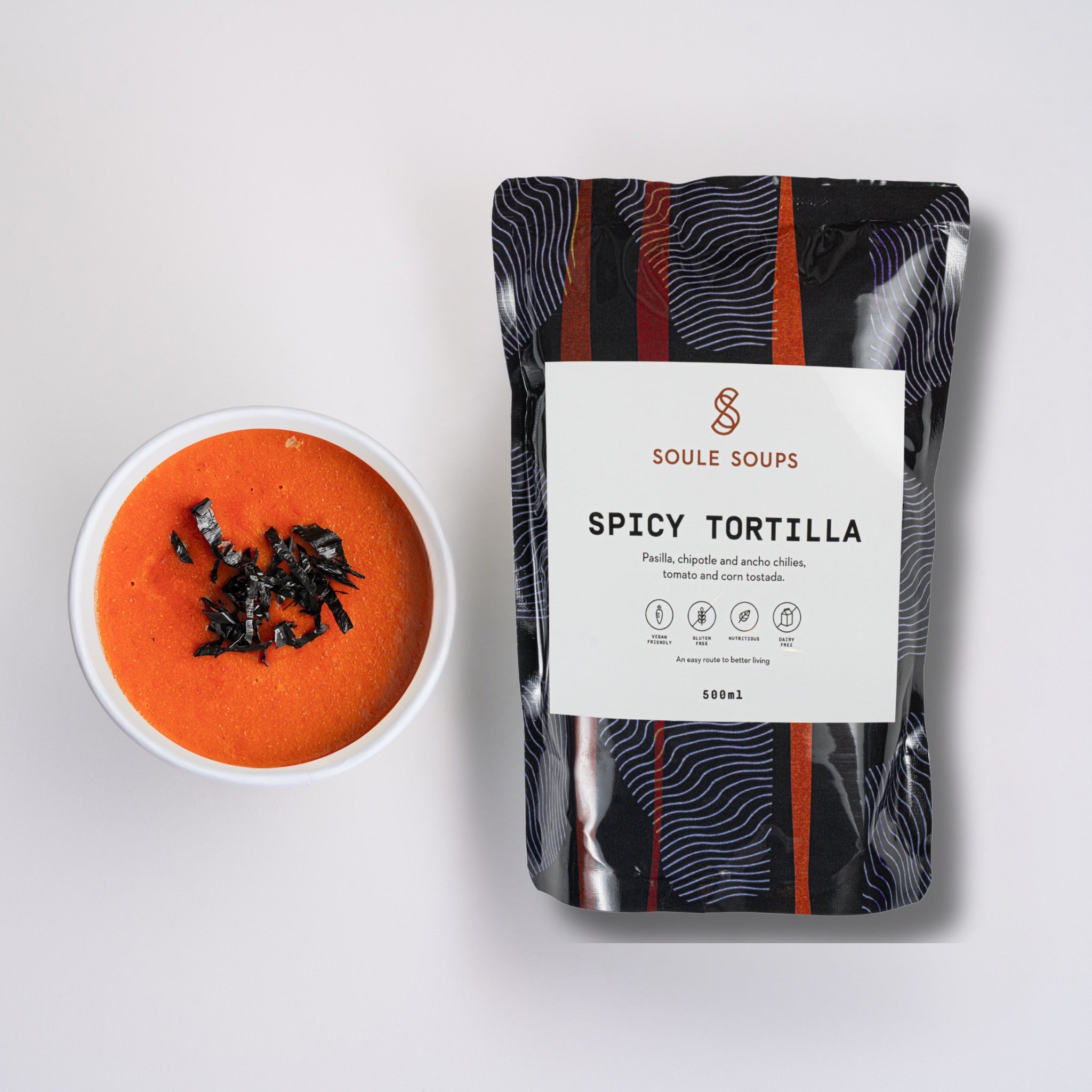 Soule Soups Spicy Tortilla soup package next to a bowl of soup on a white background