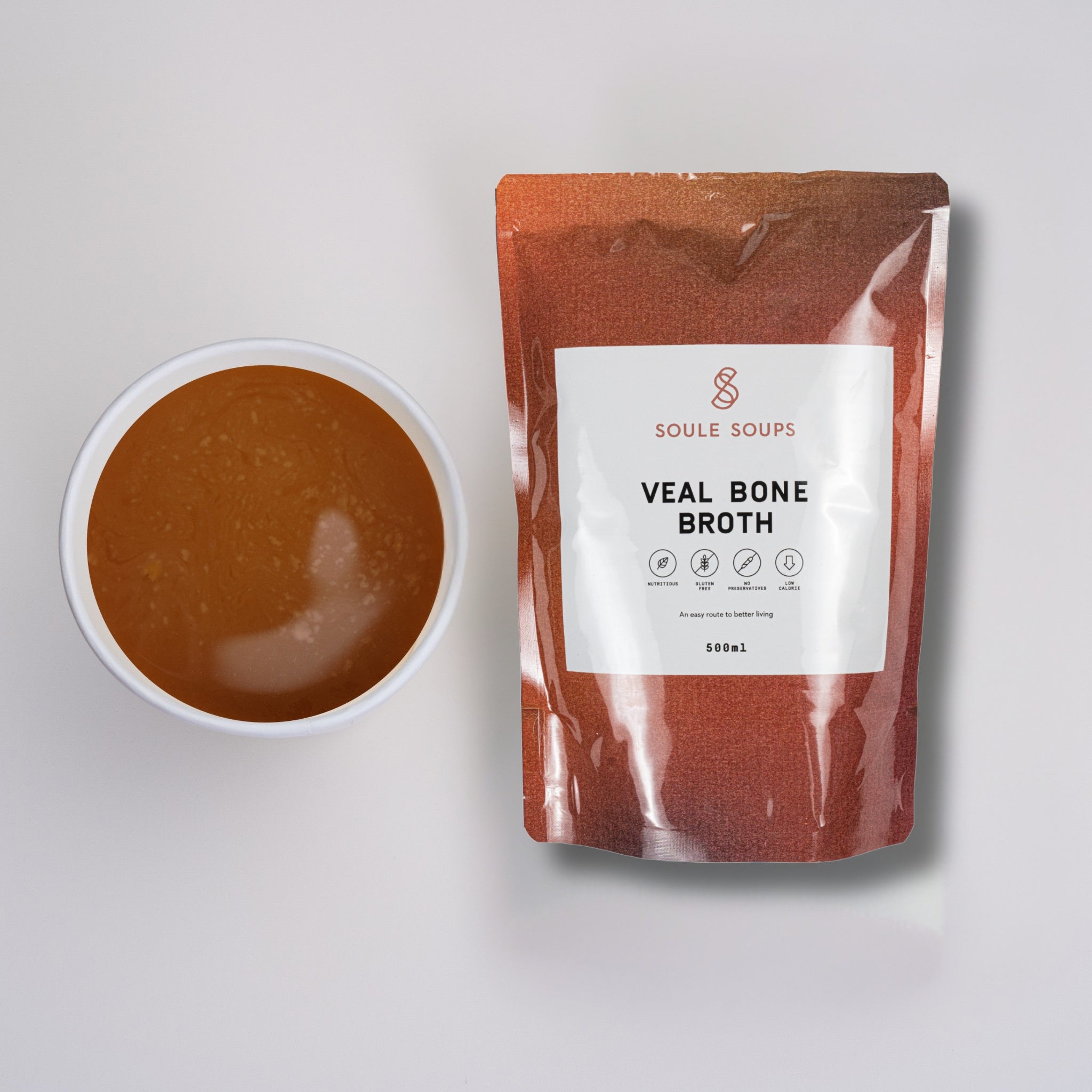 Veal bone broth package with a bowl of broth on a light gray background